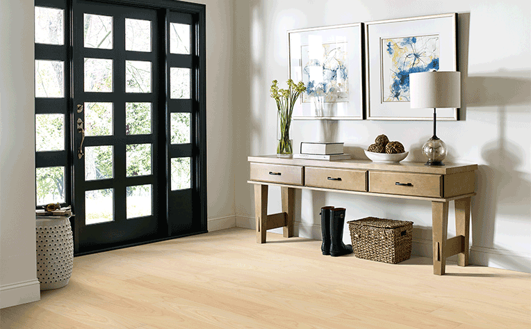 luxury vinyl plank flooring in entryway with shoes under entrytable